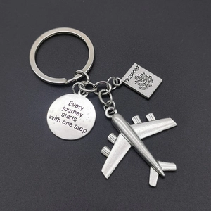 Silver airplane and passport keychain with 'Every journey starts with one step' charm