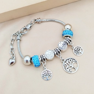 Dettaglio del bracciale a catena serpente d'argento con ciondoli albero della vita e perle