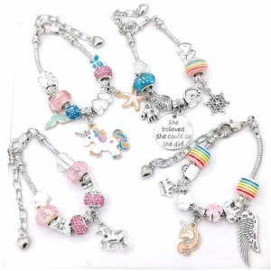Detail of four DIY charm bracelets with unicorn pendants and colorful enamel beads