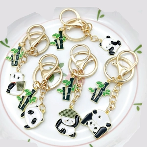 Detailed view of panda keychains with green bamboo charms in a white decorative plate