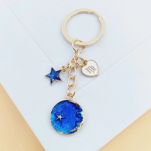 Détail du porte-clés zodiaque Vierge avec breloques étoiles et lune en émail bleu