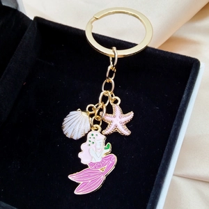 Golden mermaid starfish shell keychain pendant displayed in a velvet jewelry box
