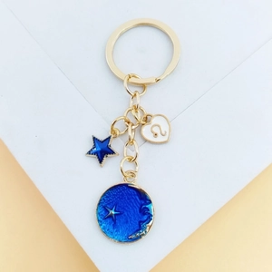 Porte-clés constellation du Lion avec étoiles bleues et lune dorée sur fond décoratif