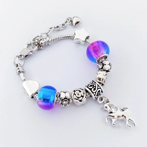Detail eines DIY-Charm-Armbands mit Einhorn-Anhänger und blau-violetten Glasperlen