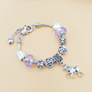 Detailansicht eines DIY-Perlenarmbands mit Einhorn-Anhänger und lila Perlen