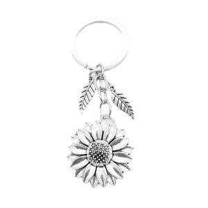 Vintage silver metal sunflower keychain with detailed petals and leaf charms on white background