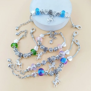 Set aus vier bunten Einhorn-Armbändern mit Herz- und Sternanhängern an versilberten Ketten