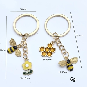 Porte-clés abeille et tournesol dorés avec finition émaillée et détails de mesure