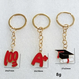 Vue macro des porte-clés de remise des diplômes avec breloque A+ et toque de docteur