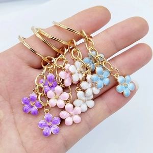 Close-up of colorful cherry blossom flower charms with gold chains and enamel finish
