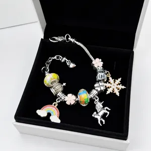 Detail of silver snake chain bracelet with rainbow, unicorn, and snowflake charms