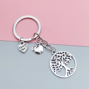 Détail du porte-clés arbre de vie argenté avec pendentifs pomme et cœur gravés Thank You