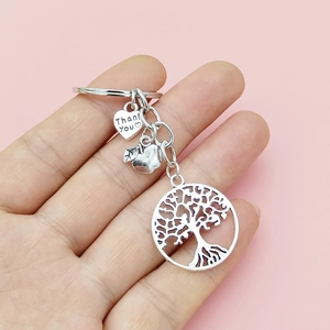 Détail du pendentif cœur Thank You avec pomme et arbre de vie sur un porte-clés