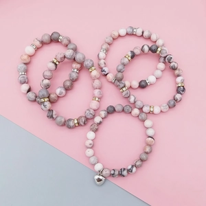 Close-up of pink zebra stone bead bracelets with sparkling rhinestone and heart charm