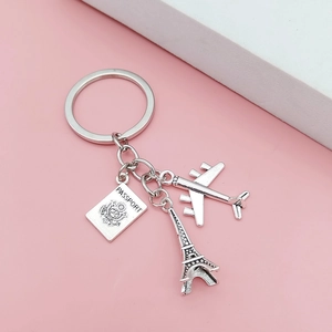 Porte-clés voyage avec avion, Tour Eiffel et passeport sur fond rose élégant