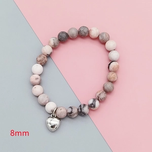 Detailed close-up of 8mm pink zebra jasper stone beads with heart charm and natural texture