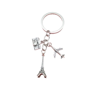 Porte-clés voyage en métal avec tour Eiffel, avion et appareil photo sur fond blanc