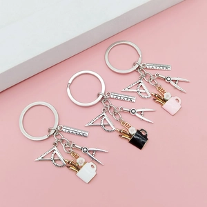 Detailed view of silver creative stationery keychains with ruler, compass, and pen holders