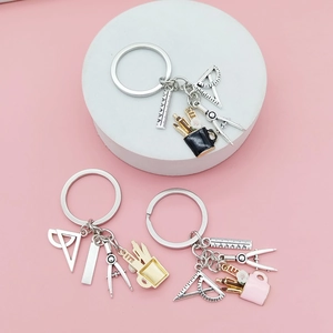 Detail view of miniature ruler and compass charms on a stationery-themed creative keychain