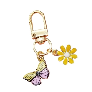 Golden daisy and butterfly keychain with yellow floral and purple insect charms