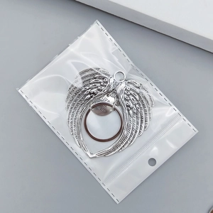 Detailed macro view of silver angel wings keychain with engraved circular live your dream tag