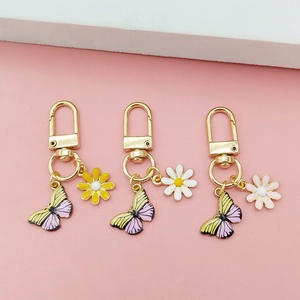 Daisy and butterfly keychain pendants set with colorful enamel flowers and gold lobster clasp