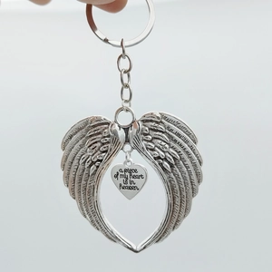 Silver angel wings keychain with heart pendant and memorial quote on white background