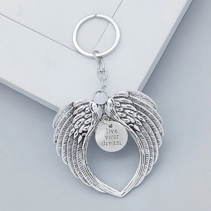 Detailed view of silver angel wing heart keychain with live your dream engraving