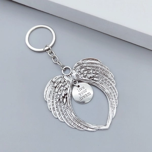 Macro detail of antique silver angel wing keychain with live your dream engraving