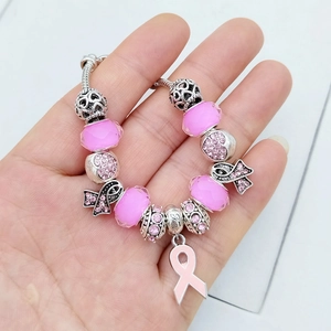 Détails des perles de cristal rose et breloques ruban rose sur bracelet argent