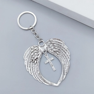 Detailed view of angel wing keychain with a rhinestone cross pendant in vintage silver