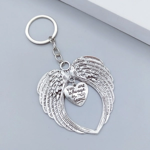 Detail view of silver angel wings keychain with engraved heart tag and sentimental quote