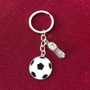 Detail of silver metal soccer keychain with classic ball and textured boot pendant