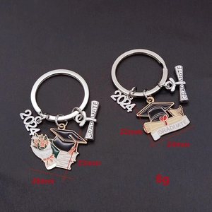 Detailed close-up of 2024 graduation metal keychains with diploma and mortarboard charms