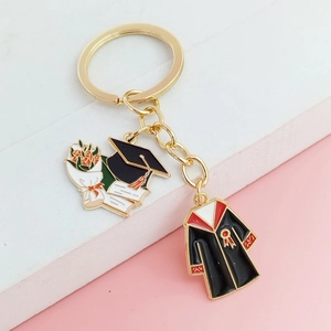 Détail d'un porte-clés de remise des diplômes avec chapeau, fleurs et breloques de robe