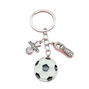 DIY soccer themed metal keychain with football and shoe charms on a white background