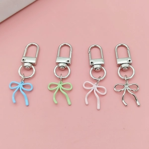 Close-up of four colorful alloy bowknot pendants with smooth painted finish for keychains