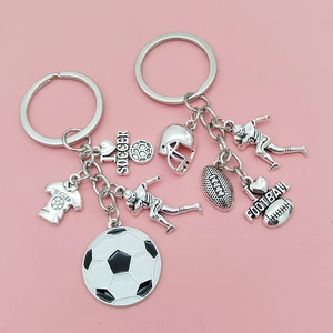 Porte-clés de sport détaillés avec pendentifs de football sur un fond rose uni