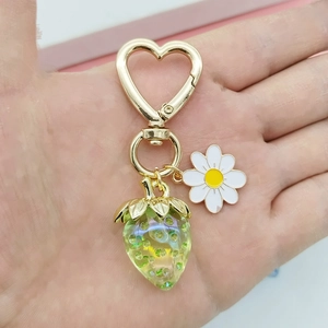 Détail du porte-clés fraise verte et marguerite avec un fermoir en forme de cœur doré