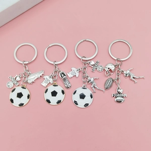 Détail de porte-clés thématiques football et rugby avec pendentifs émaillés sur fond rose