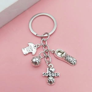 Détails macro de breloques de football en argent vintage et chaussure sur porte-clés