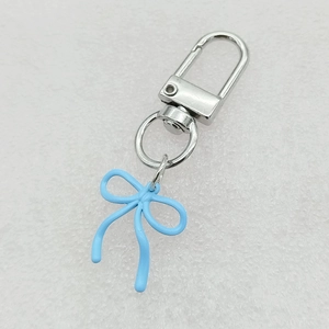 Detailed view of light blue lacquer bow charm with silver metal lobster clasp and ring