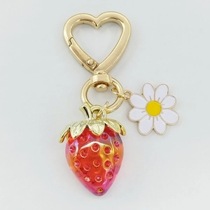 Détail du fermoir doré en cœur avec breloque marguerite et fraise scintillante