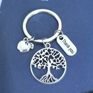 Détail de porte-clés en alliage argenté avec pomme, arbre de vie et pendentif Thank You
