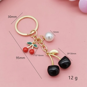 Creative cherry keychain with black and red fruit charms, white pearl and golden metal chain