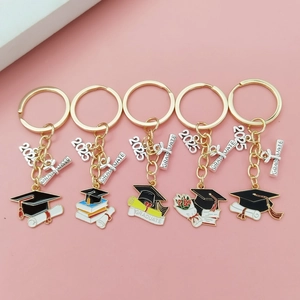Porte-clés de remise de diplôme 2025 avec breloques chapeau et parchemin sur fond rose