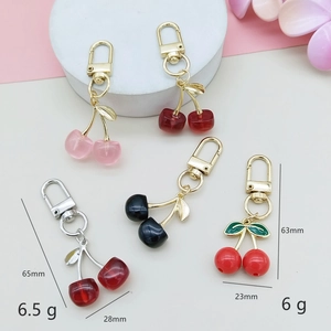 Detail view of acrylic cherry keychains showing dimensions 65mm and metal hooks