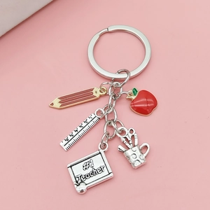Close-up of a teacher-themed keychain with charms like a red apple and #1 teacher blackboard