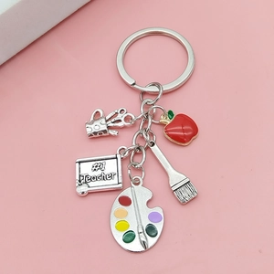 Detailed view of metal teacher keychain with red apple, palette, and #1 Teacher charms