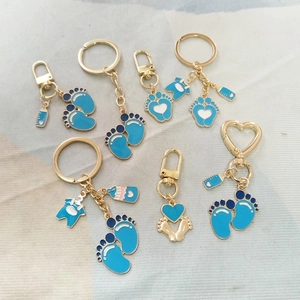 Detail van blauwe en witte emaille babybedeltjes met gouden karabijnsluitingen